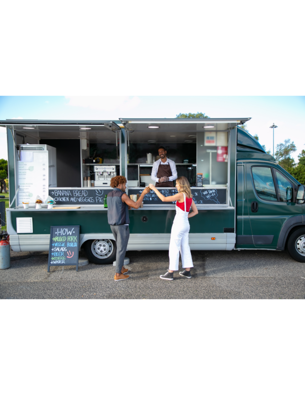People share their goods from a food truck.