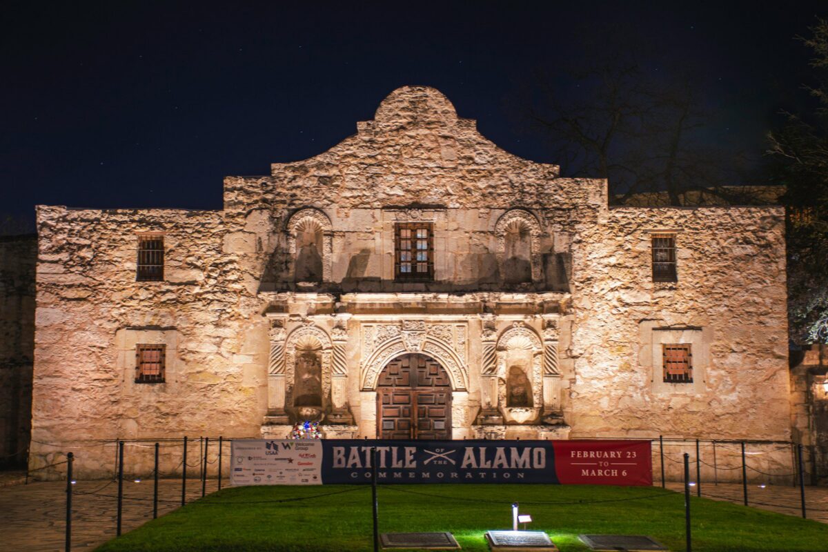 An image depicting the Alamo Church, located in San Antonio, Texas. A banner displays the
