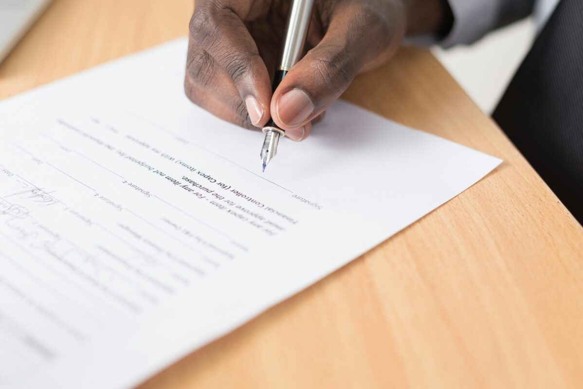 Man getting ready to sign a paper.