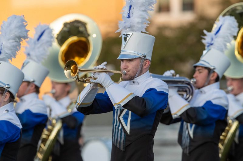 Boy is playin that trumpet.